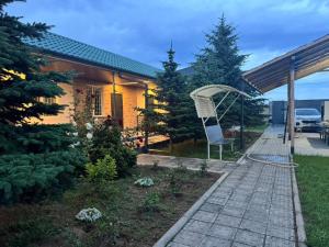 a house with a chair in the yard at Guest house BIKA in Chon-Sary-Oy