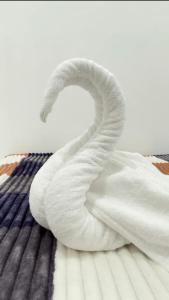 a white towel snake sitting on a bed at TJ Signature Spaces in Point Pedro
