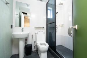 ein Badezimmer mit Toilette, Waschbecken und Dusche in der Unterkunft G1 Lodge Design Hotel in Baguio City