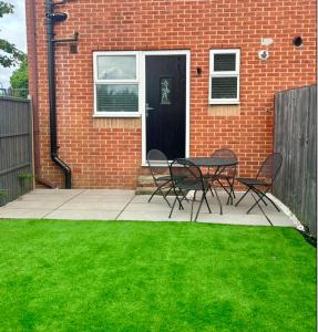 a patio with a table and chairs in front of a brick building at 5 Richmond Croft in Leeds