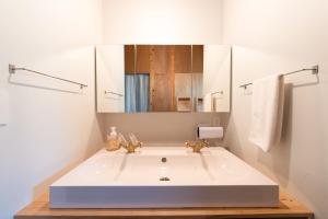 a bathroom with a white sink and a mirror at 波と月 in Oarai