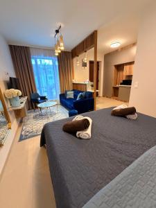 a bedroom with a bed and a living room at CasaBlanca vendégház in Abádszalók