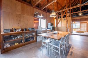 a large kitchen with a wooden table and chairs at 波と月 in Oarai