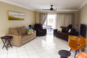 a living room with a couch and a chair at Perfect holiday destination! in Jeffreys Bay