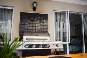 a kitchen with a stove top oven in a room at Perfect holiday destination! in Jeffreys Bay +69 photos