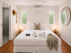 a bedroom with a white bed and a mirror at Bayhaven Lodge in Byron Bay +90 photos