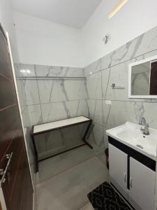 a white bathroom with a sink and a mirror at Romins Park in Kodanad
