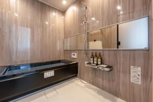 a bathroom with a shower with bottles of wine at 波と月 in Oarai
