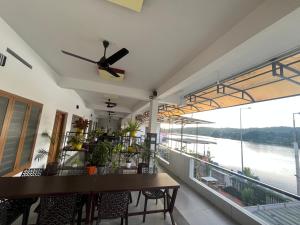 a dining room with a ceiling fan and a view of the water at Romins Park in Kodanad