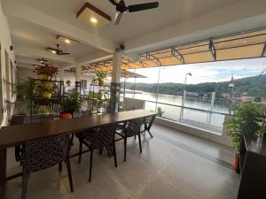 a dining room with a table and chairs and a large window at Romins Park in Kodanad