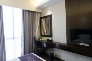 a hotel room with a desk and a mirror at Meritin Hotel in Kuching