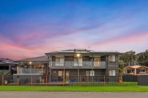a large house with a fence in front of it at Marea at Tanilba Bay in Lemon Tree Passage