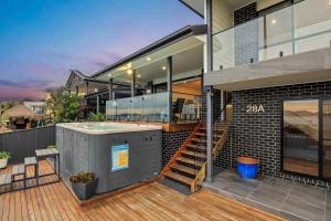 a house with a hot tub on a deck at Marea at Tanilba Bay in Lemon Tree Passage