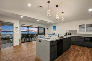 a large kitchen with a view of the ocean at Marea at Tanilba Bay in Lemon Tree Passage +34 photos