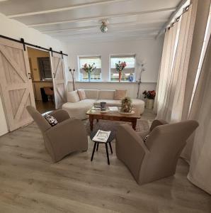 a living room with a couch and chairs and a table at Effe d'r ut in Hengelo +14 photos