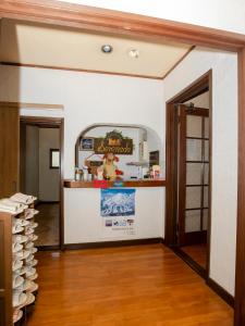 a room with a kitchen with a counter and a doorway at Pension Serenade in Hakuba +77 photos