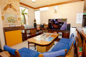 a living room with a table and a tv at Pension Serenade in Hakuba