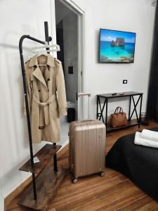 a coat and suitcase on a stand in a room at Relax Rooms in Trapani