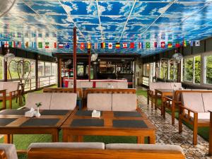 a restaurant with tables and chairs and a blue ceiling at River Side Hotel Pvt Ltd in Tanahun