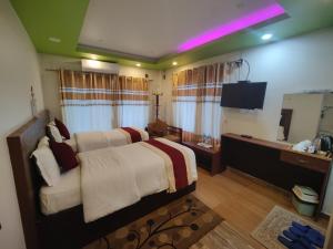 a bedroom with a large bed and a television at River Side Hotel Pvt Ltd in Tanahun +16 photos