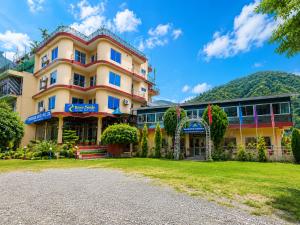 a large building with a lawn in front of it at River Side Hotel Pvt Ltd in Tanahun