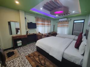 a bedroom with a large white bed and a television at River Side Hotel Pvt Ltd in Tanahun