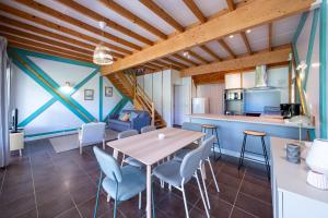 a dining room and kitchen with a table and chairs at Chalet avec jardin et vue 6 personnes in Espezel +21 photos