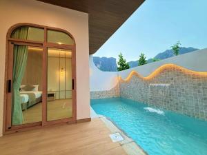 a bedroom and a swimming pool in a house at The Apex private pool villa Krabi in Krabi