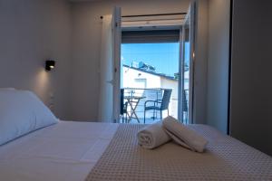 ein Schlafzimmer mit einem Bett und Blick auf einen Balkon in der Unterkunft ERA Suites in Stomio
