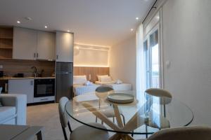 eine Küche und ein Wohnzimmer mit einem Glastisch und Stühlen in der Unterkunft ERA Suites in Stomio
