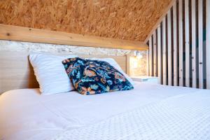 a white bed with a pillow on top of it at Chalet avec jardin et vue 6 personnes in Espezel