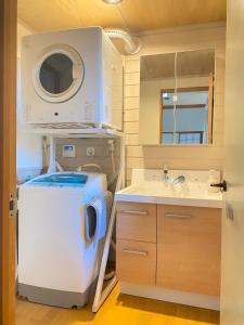 a washing machine in a bathroom with a sink at Villa Mon Petit Nid Komoro in Komoro +55 photos