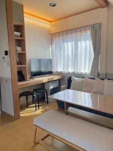 a living room with a couch and a desk at Villa Mon Petit Nid Komoro in Komoro
