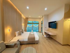 a bedroom with a bed and a desk and a television at The Apex private pool villa Krabi in Krabi
