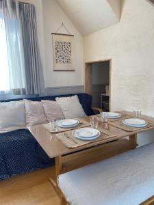 a living room with a table and a couch at Villa Mon Petit Nid Komoro in Komoro