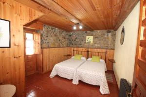 a bedroom with a bed in a room with wooden walls at La Llosa II in Villaviciosa