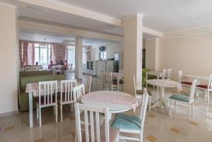 a dining room with tables and chairs and a kitchen at Hotel Morskaya Volna in Anapa
