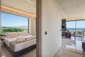 a bedroom with a bed and a view of the ocean at Infinite View Villa in Platanias +69 photos