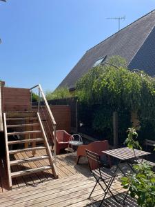 a wooden deck with a staircase and a table and chairs at Le kesson in Saint-Brieuc