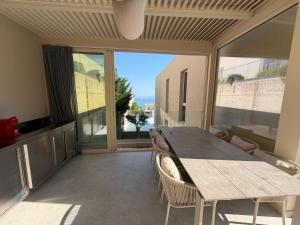 a dining room with a table and chairs and a large window at Villa RRE Green Coast in Palasë