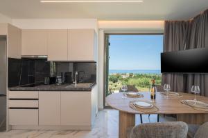 a kitchen and dining room with a table and a window at Infinite View Villa in Platanias
