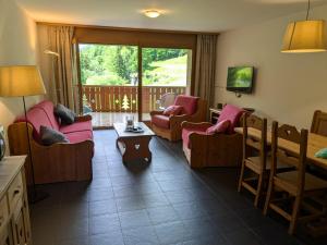 a living room with pink chairs and a table at Pointe de l'Au in Val-d'Illiez