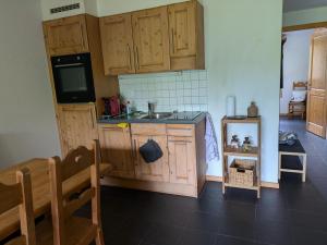a kitchen with wooden cabinets and a sink at Pointe de l'Au in Val-d'Illiez +6 photos
