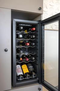 a refrigerator filled with lots of wine bottles at Infinite View Villa in Platanias