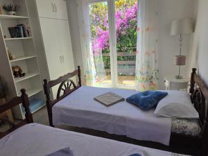 two twin beds in a room with a window at Villa Letina in Sukošan