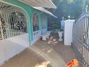 a green and white building with a gate and two dogs at Ruby's Place in Boscobel