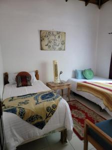 a bedroom with two beds and a table and a rug at Ruby's Place in Boscobel