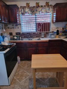 a kitchen with wooden cabinets and a sink and a table at Ruby's Place in Boscobel