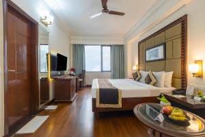 a hotel room with a bed and a table at Foxoso The BMK - A Corporate Hotel in New Delhi +40 photos