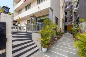 a building with stairs and potted plants on it at Foxoso The BMK - A Corporate Hotel in New Delhi